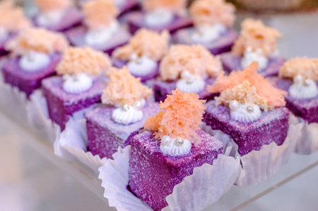 Delicious wedding reception sweets luxury purple color desserts with edible pearl and edible crystal stones on top on glass plate. Candy bar desser.の写真素材