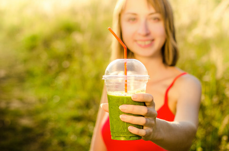 Diet. Drink smoothie.  Smiling healthy woman drinking fresh green detox vegetable juice. Healthy lifestyle, vegetarian food. Nutrition Concept.の写真素材