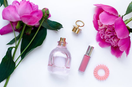 Pink peony flower bottle of perfume and lipstick pink woman mood Flat lay Nature concept on white background with copy space. Mother's Day and spring background concept.の写真素材