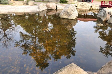 A small artificial lake and reflection in its still water.の写真素材