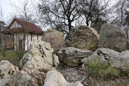 Huge boulder stones are near a small house.の写真素材