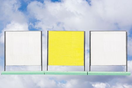 Three advertising boards under the skyの写真素材