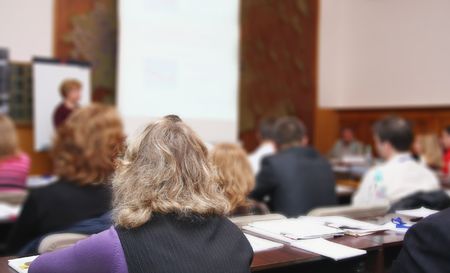 The audience listens to the acting in a conference hall. Focus is under the woman on the front groundの写真素材
