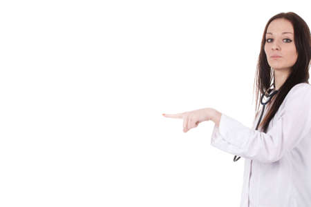 Standing woman doctor with stethoscope in a white robe. She points with a finger to the leftt part of an image. The place on the image to the left of her is empty for a textの写真素材