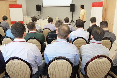 The audience listens to the acting in a conference hall