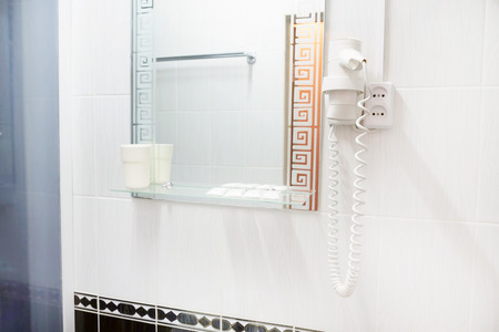 White hair dryer on wall in bathroomの写真素材