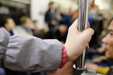 MOSCOW, RUSSIA  -  APRIL 12, 2015: Sokolnicheskaya line - the first line of the Moscow metro. 
Girls hand holding onto the handrail in the subwayのeditorial素材