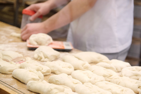 Chefs forming dough in order to prepare breadの写真素材