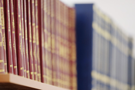 The image of books on the shelf in a library. The books on the background are blurredの写真素材