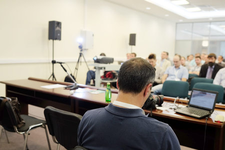 The audience listens to the acting in a conference hall