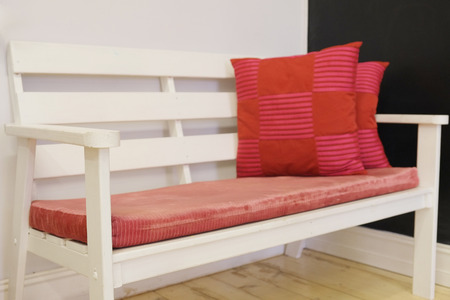 White bench with red pillowsの写真素材