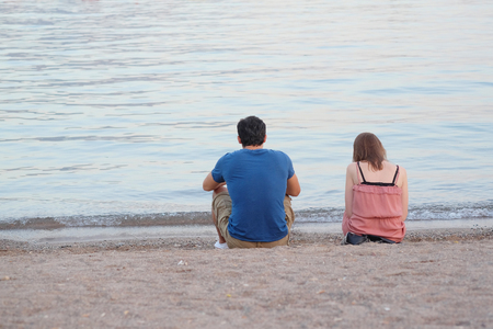 Boy and girl sit on a beach of Adriatic sea in Budva, Montenegroの写真素材
