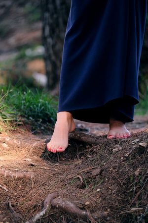 Young girl's foots on a wooden roadの写真素材