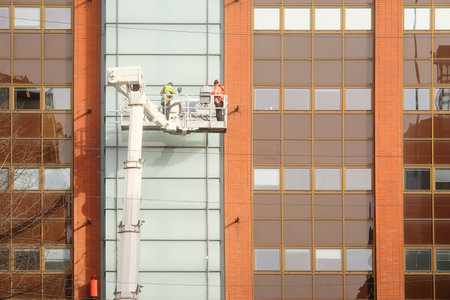 workers is engaged in restoration of the modern multi-storey building in Helsinki, Finland