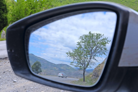 reflection of the mountain road in a car rear-view mirrorの写真素材
