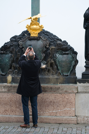 Prague, Czechia - November, 21, 2016: tourist makes photo on Charles Bridge in Prague, Czechiaのeditorial素材