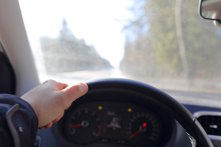 Interior of a car with hands on a steering wheelの写真素材