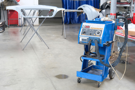 Car repair station with welder jn a frontgroundの写真素材