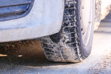 Car wheel on a winter road close upの写真素材