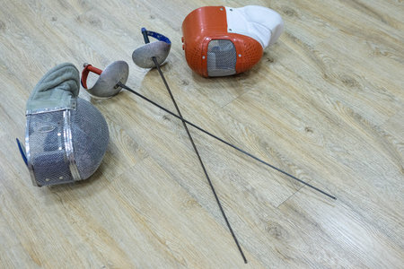 Sport rapiers and helmets close up
