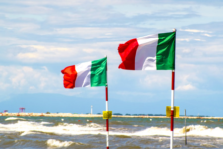 sea beach in Sottomarina, Italy with the Italian flags on a frontgroundの写真素材