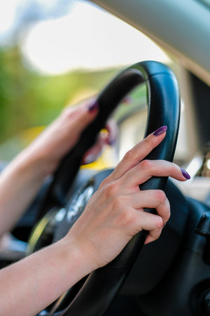 Girl's hand on a stearing wheel