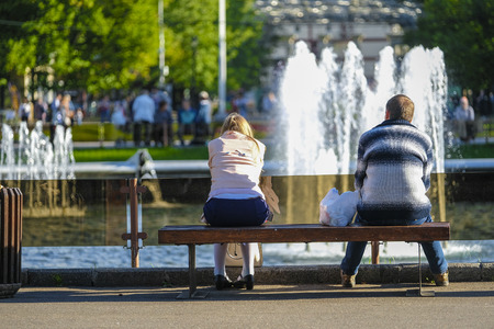 Moscow, Russia: people sit on a bench in Moscow park Sokolnikiの写真素材