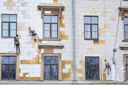 St. Petersburg, Russia - November, 6, 2021: Steeplejacks work on a wall of a house in St....