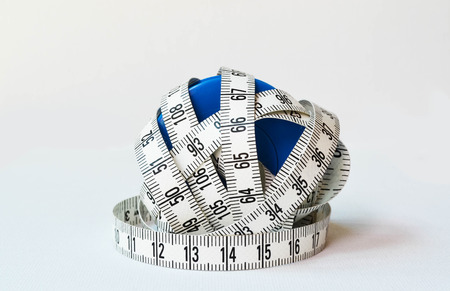 White measuring tape in blue plastic bearings on white backgroundの写真素材