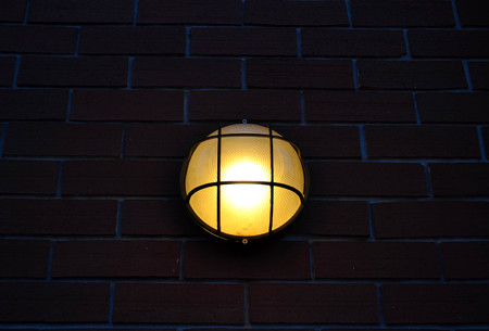 Lamp hanging on brick wall at night - retro styleの写真素材