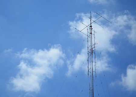 Television antenna against fluffy blue skyの写真素材