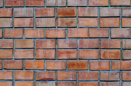 Grunge and pale orange mansory brick wall background