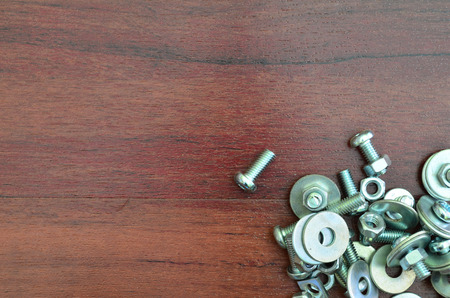 Metal screw and nut with copy space on wooden background, mechanic toolの写真素材