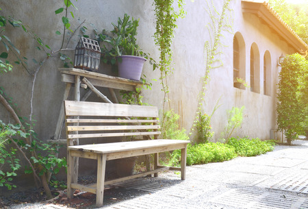 Old wooden bench in the garden under warm sun lightの写真素材