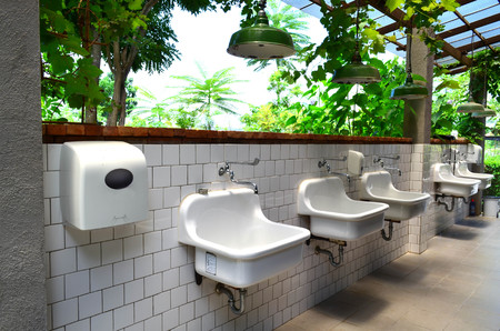 Vintage white ceramic wash basin with soap dispenser and hanging lampの写真素材