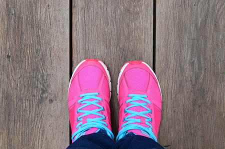 Woman Leg With Pink Sport Shoe On Brown Wood Slat Floorの写真素材