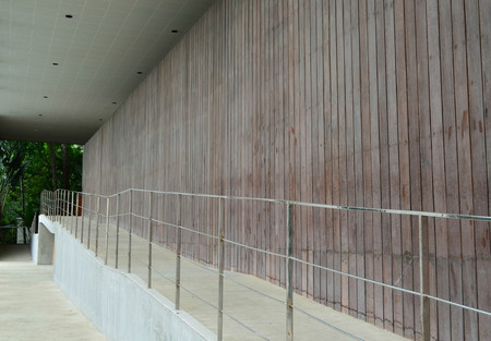 Slope concrete walkway with stainless rail and wood wall panelの写真素材