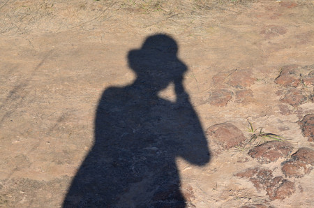 Figure shadow of woman tourist wearing hat against earth floorの写真素材