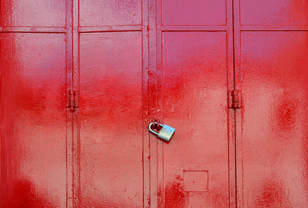 Red metal sheet door was locked with padlock, security conceptの写真素材