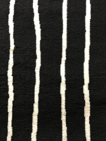 Close up of texture of black carpet with white stripe