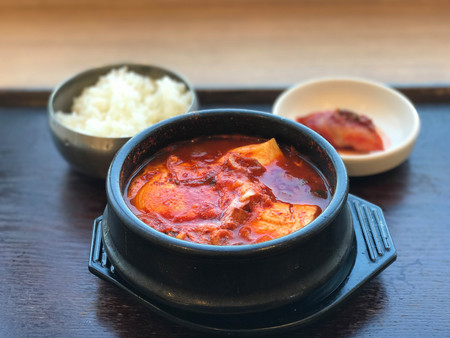 Traditional Korean food, kimchi soup in clay pot and wooden trayの写真素材
