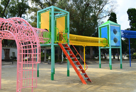 Colorful children playground equipment in public park in the city, under sun light