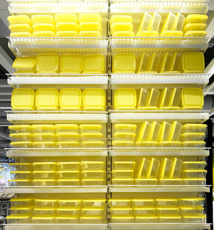 Stack of yellow food containers in kitchenware storeの写真素材