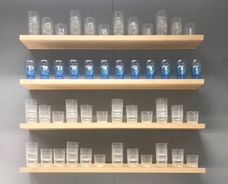 Empty glass decorated on wooden shelf and gray wallの写真素材