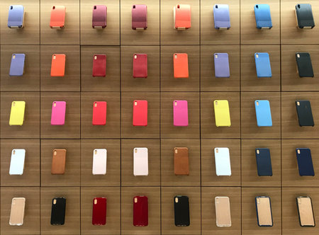 Colorful smartphone case or cover displayed on wooden shelf in phone shop
