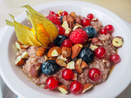 Delicious breakfast or brunch oatmeal with berries, nuts and fruitsの写真素材