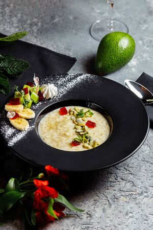 Oatmeal with berries, fruits and marmalade on vintage teal table top view in flat lay style. Hot and healthy breakfast and diet food.の写真素材