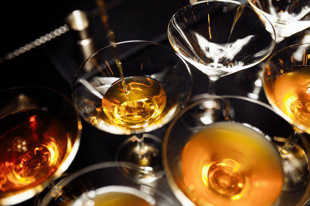 glass with martini with olive inside. Close up view of glass with club drink on dark foggy toned...