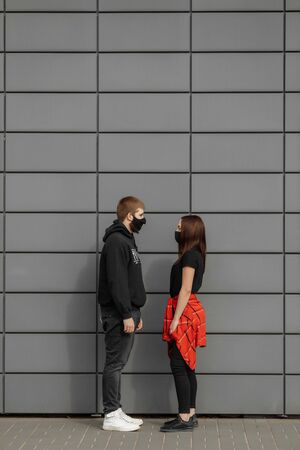 Couple in love, man and woman in protective medical mask on face on street. quarantineconcept. Guy, girl against world pandemic coronavirus, virus protectionの写真素材