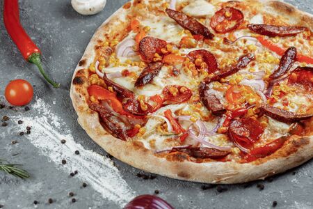 Delicious pizza sausages, chicken, tomato sauce and mozzarellaの写真素材